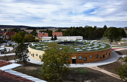 Pavilon základní školy v Líbeznicích u Prahy je určen pro 240 dětí v osmi kmenových učebnách; vnější fasáda rondelu je zděná s obkladem z nehoblovaných modřínových prken a nepravidelně rozmístěnými okenními otvory, fasáda do atr