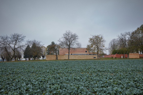 Nová smuteční síň prodlužuje linii hřbitovní zdi a stává se součástí panoramatu v podhůří Orlických hor.