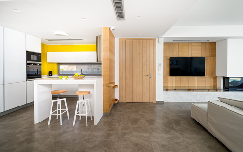 Vzdušný obývací pokoj je spojený s kuchyňským koutem a jídelnou. Nábytek je laděn do světlých barev. 