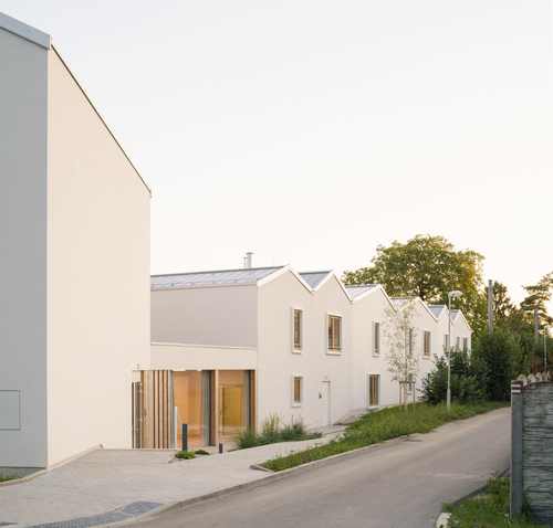 S výškovou regulací v území se projekt vyrovnává uložením podlahy přízemí do úrovně vnitřní zahrady, zatímco uliční fasáda je de facto zakopána a parapety oken jsou v úrovni stávajícího terénu.