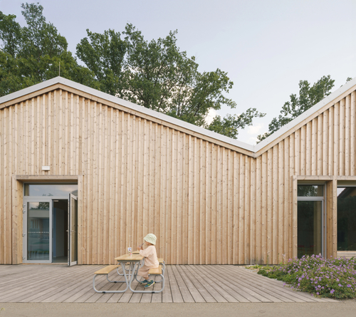 Zdivo mateřské školy je kryté dřevěným obkladem.