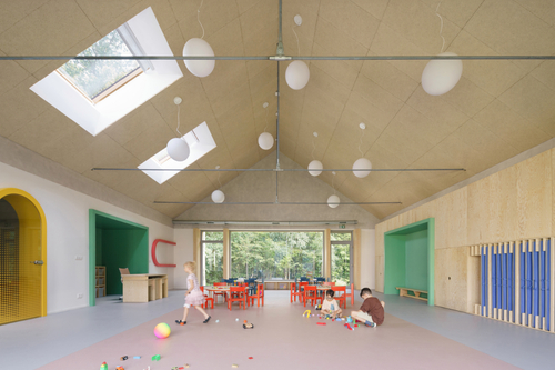 Střešní tvarosloví se propisuje i do interiéru, kde zvláště v herně školky vytváří velký otevřený prostor; díky oboustrannému velkému prosklení, k lesu i do zahrady, je zajištěno proslunění i dostatečné denní osvětlení.