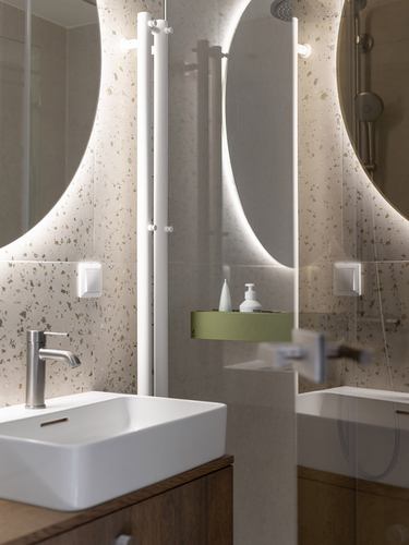 Jedna z koupelen svou atmosférou připomíná hotelové koupelny. Na dveřích sprchy se uplatnily magnetické poličky z autorské kolekce be_myshelf.